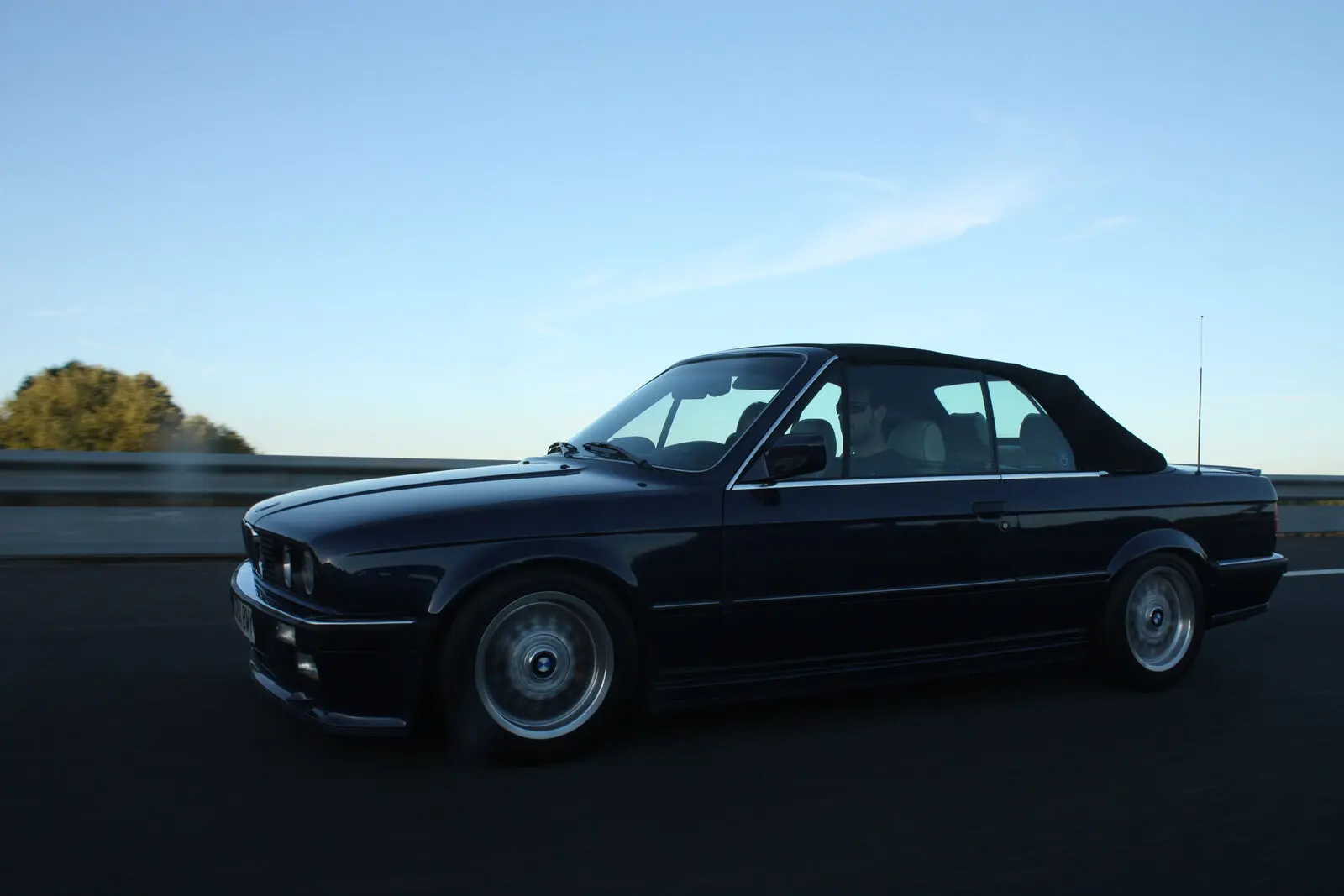 Dark blue BMW E30 325i convertible at dusk