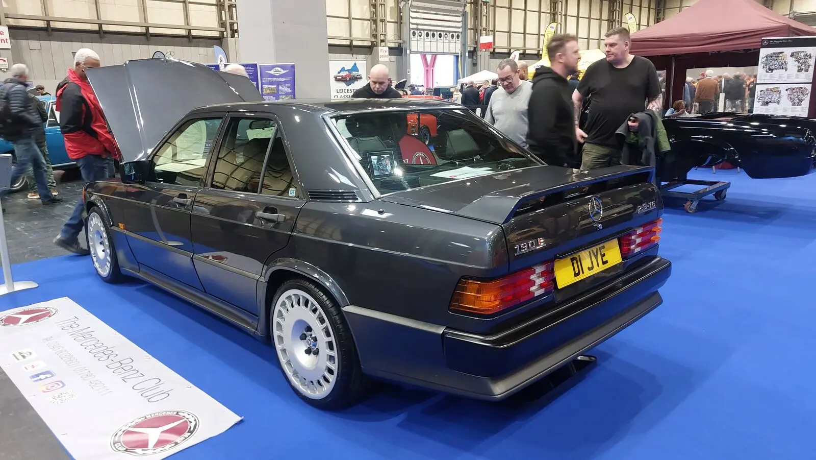 Dark Mercedes-Benz 190E 2.3-16 on display at an indoor show