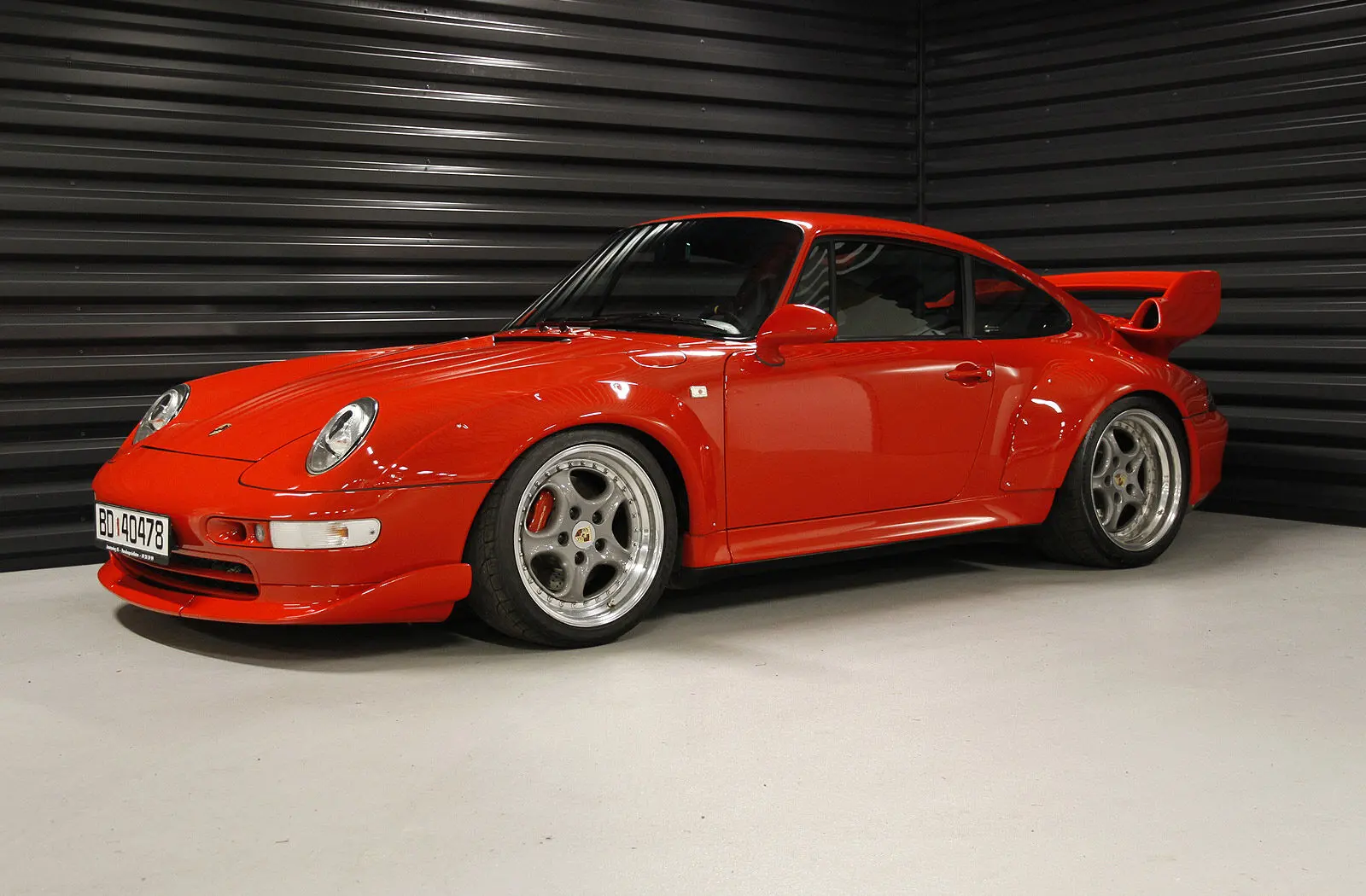 Red Porsche 911 GT2 of the 993 generation in a dark garage